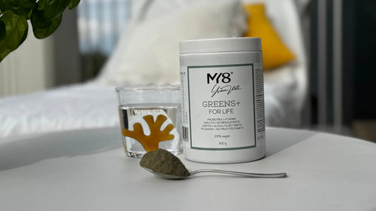 Probiotika Gesundheitsroutine 2025 mit MY8® Greens und einem Glas Wasser auf einem Tisch.